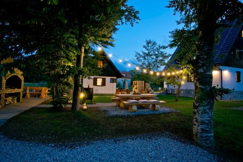 a backyard with a wooden picnic table and lights at B&B Plitvice Holiday Lodge in Plitvička Jezera