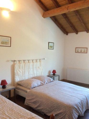 a bedroom with two beds and two tables with lamps at GÎTE EN COMMINGES in Franquevielle