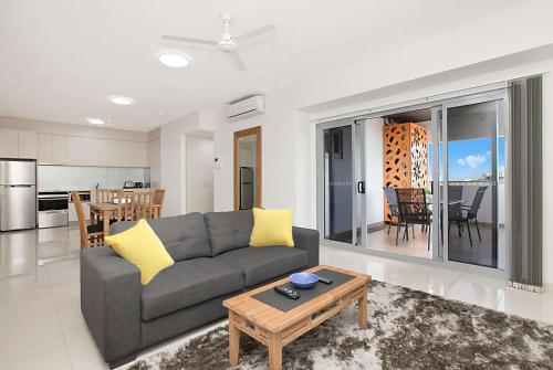 a living room with a couch and a table at Ramada Suites by Wyndham Zen Quarter Darwin in Darwin