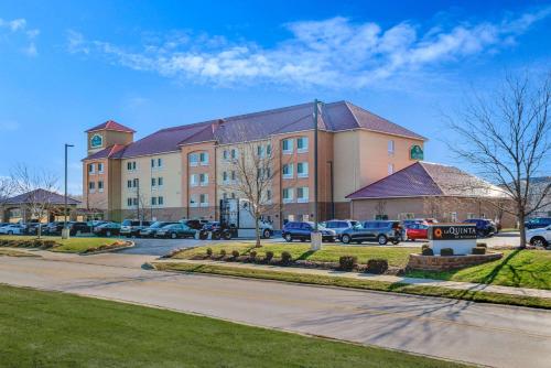 a large building with cars parked in a parking lot at La Quinta by Wyndham Indianapolis Airport Plainfield in Plainfield