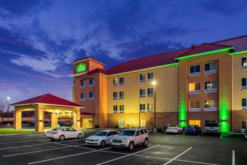 a hotel with cars parked in a parking lot at La Quinta by Wyndham Indianapolis Airport Plainfield in Plainfield