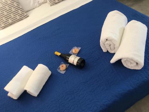 a blue table with towels and a bottle of wine at Case vacanze Spagnola 106 in Marsala
