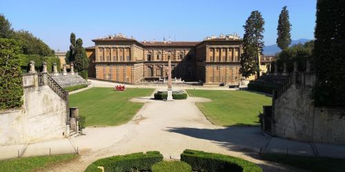 un gran edificio con un jardín delante de él en Hotel Victoria en Florence