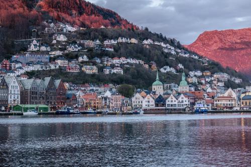 a town on a hill next to a body of water at Home Hotel Bryggen in Bergen