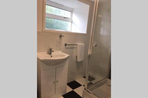 a bathroom with a sink and a shower at Crofters Cottage at 100 Midtown in Melness