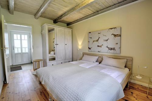 - une chambre avec un grand lit blanc dans l'établissement fewo1846 - Rotes Haus - idyllisch gelegenes Haus mit 2 Schlafzimmern und großem Grundstück, à Husby