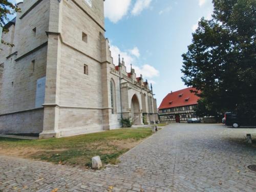 a large building with a clock tower on a street at Pension Bergstube in Bad Langensalza