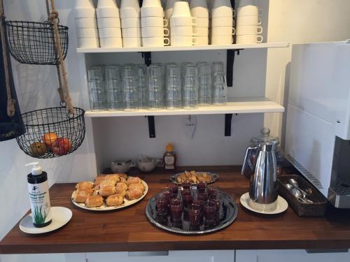 a kitchen counter with plates of food and pastries at Marsfjäll Mountain Lodge Vandrarhem i Saxnäs in Saxnäs