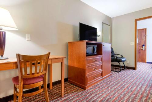 a hotel room with a desk and a tv and a chair at Econo Lodge Lakeview in Marquette