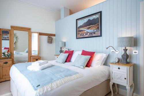 a bedroom with a large bed with red and blue pillows at Art House Apartments in Inverness