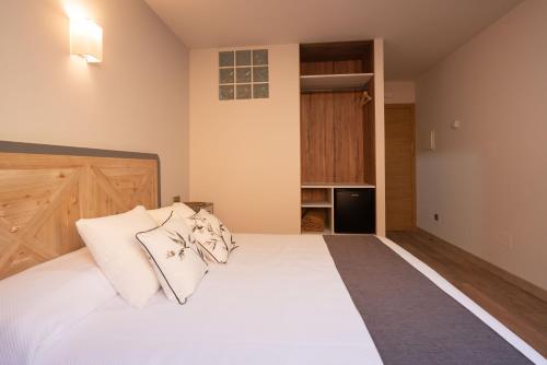 a bedroom with a white bed with two pillows at Casa Gabriela Hotel in Jiménez de Jamuz