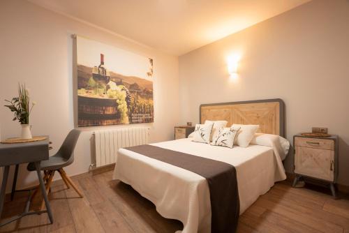 a bedroom with a bed and a desk and a painting at Casa Gabriela Hotel in Jiménez de Jamuz
