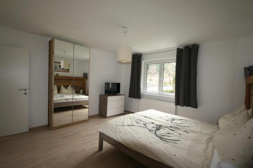 a bedroom with a bed and a mirror at Apartment Daum - Deine Ferienwohnung in Mühlbach am Hochkönig in Mühlbach am Hochkönig