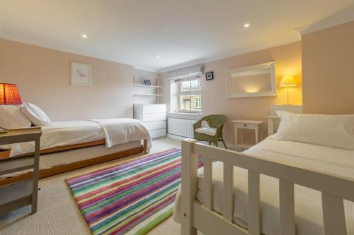 a bedroom with two beds and a desk and a chair at Beadale Cottage in Ampleforth