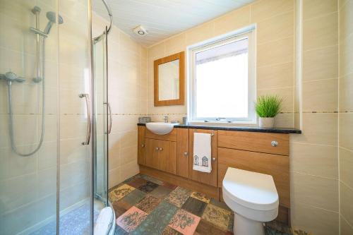 uma casa de banho com um chuveiro, um WC e um lavatório. em FerryView em Broughty Ferry