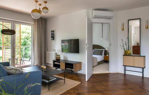 a living room with a blue couch and a tv at Apartament LUMOS by Pedro Polanica in Polanica-Zdrój