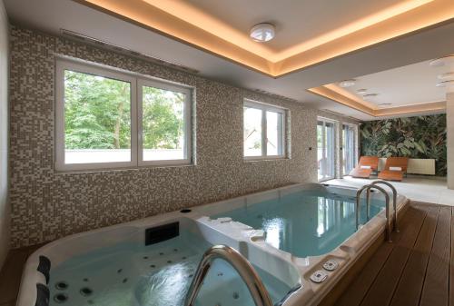 a large bathroom with a large hot tub at Apartament LUMOS by Pedro Polanica in Polanica-Zdrój
