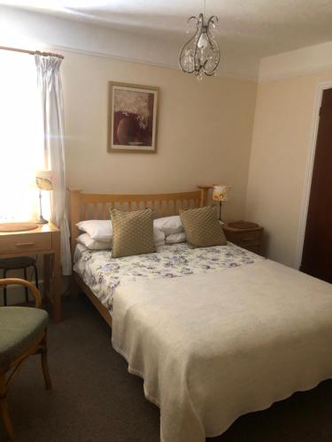 a bedroom with a bed and a chandelier at Auplands en-suite Rooms in Lymington