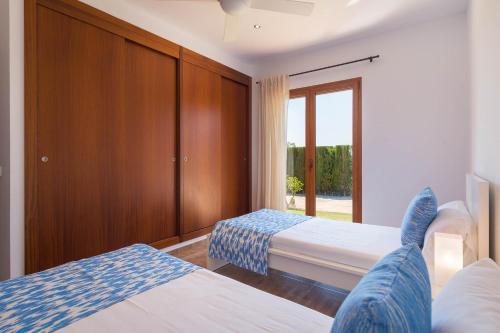 a hotel room with two beds and a window at Villa Can Corme in Sa Pobla