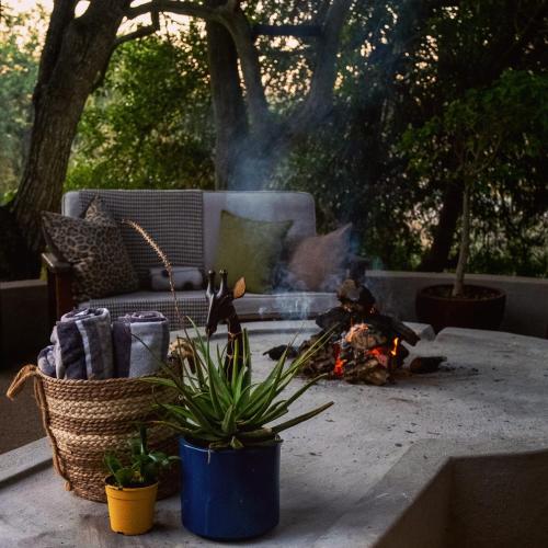 a fire pit on a patio with a couch and a table at Leopard's Lair Bush Lodge in Hoedspruit
