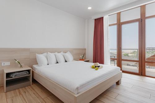 a bedroom with a white bed and a large window at Lucky Residence in Zatoka