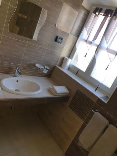 ein Bad mit einem Waschbecken und einem Spiegel in der Unterkunft Šmartno Apartmaji Sobe Joško in Šmartno
