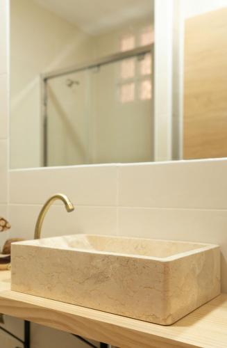 a stone sink in front of a bathroom mirror at Casa Gabriela Hotel in Jiménez de Jamuz