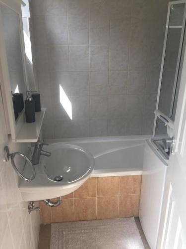 y baño con lavabo y bañera. en Kistímár Apartman, en Pécs