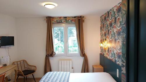 a bedroom with a bed and a window at Logis Hôtel Vannes Nord Le Clos Des Hortensias in Locqueltas