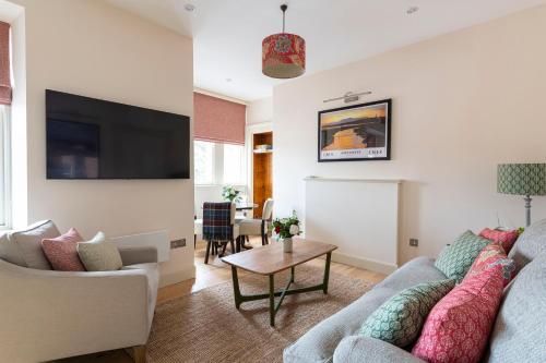 a living room with a couch and a tv at Art House Apartments in Inverness