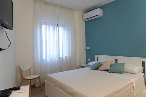 a bedroom with a bed with a window and a desk at Il vicolo di Clara B&B in Diamante