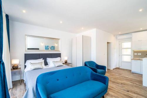 ein Schlafzimmer mit einem blauen Bett und einem blauen Sofa in der Unterkunft Corallium Blue in Pomena