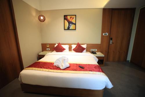 a bedroom with a bed with a stuffed animal on it at The Byke Delotel in Mumbai