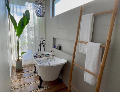 a bathroom with a white bath tub and a plant at Ahana Resort El Nido in El Nido