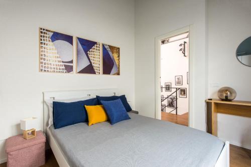 a bedroom with a bed with blue and yellow pillows at Casa con giardino all'ex Fabbrica di Pomodoro in Palermo