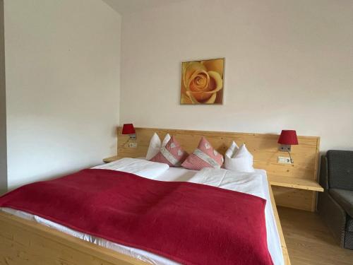 a bedroom with a large bed with a red blanket at Hotel Berghof in Sonnenalpe Nassfeld