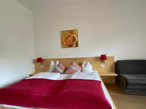 a bedroom with a large bed with a red blanket at Hotel Berghof in Sonnenalpe Nassfeld