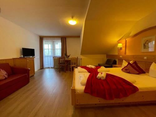 a hotel room with two beds and a couch at Hotel Berghof in Sonnenalpe Nassfeld