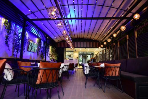 a restaurant with a purple ceiling and tables and chairs at Hotel Comfort in Tirana