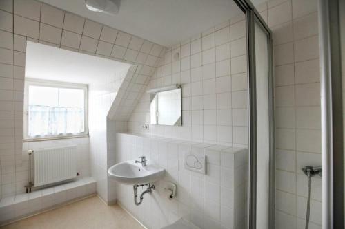 une salle de bain blanche avec un lavabo et une fenêtre dans l'établissement Gästehaus Goethe-Institut Schwäbisch Hall, à Schwäbisch Hall