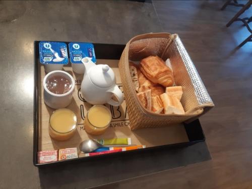 ein Tablett mit einem Korb Brot und Milch in der Unterkunft Chambres d'Hôtes vue mer entre Plestin les Grèves et locquirec in Plestin-les-Grèves