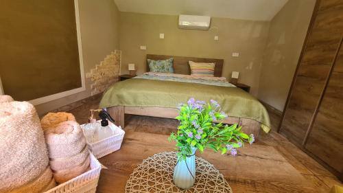 a bedroom with a bed and a vase of flowers at Casa Lira Orșova in Orşova