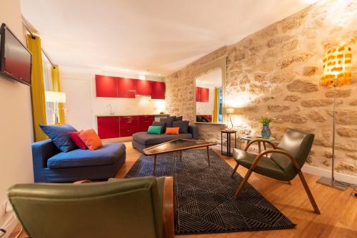 ein Wohnzimmer mit einem Sofa, Stühlen und einem Tisch in der Unterkunft Popy in Paris