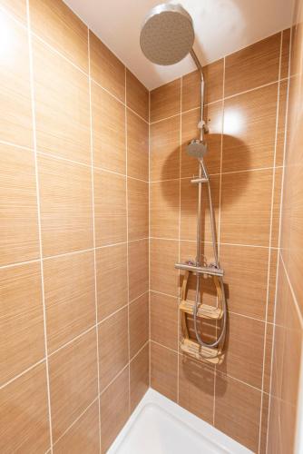 La salle de bains est pourvue d'une douche et de carrelage en bois. dans l'établissement Popy, à Paris