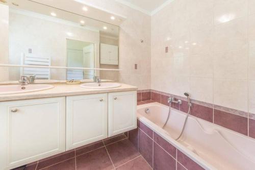 une salle de bain avec deux lavabos et une baignoire et une baignoire dans l'établissement Villa -Vue panoramique splendide -Piscine privée, à Auribeau-sur-Siagne