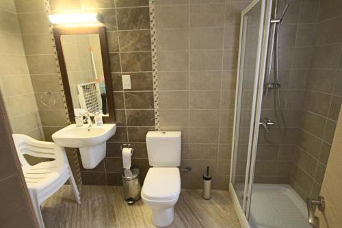 Un baño con inodoro, lavabo y ducha. en Fig Tree Bay Apartments, en Protaras