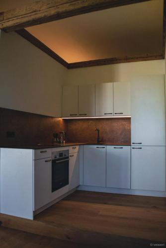 a kitchen with white cabinets and a sink at Innviertler Versailles in Aurolzmünster