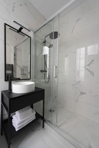 une salle de bain avec un lavabo et une douche en verre dans l'établissement Time Line, à Paris