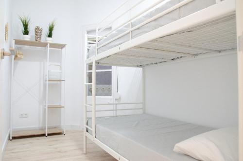 1 dormitorio con paredes blancas y literas blancas en Apartamento NUEVO con encanto en SAGRADA FAMILIA en Barcelona