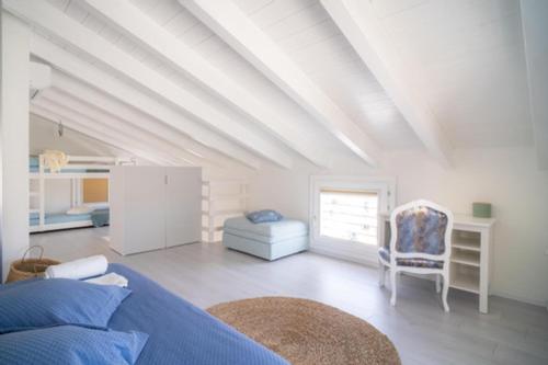 a white room with a bed and a chair at MERMAID'S HOUSE in Isola Rossa